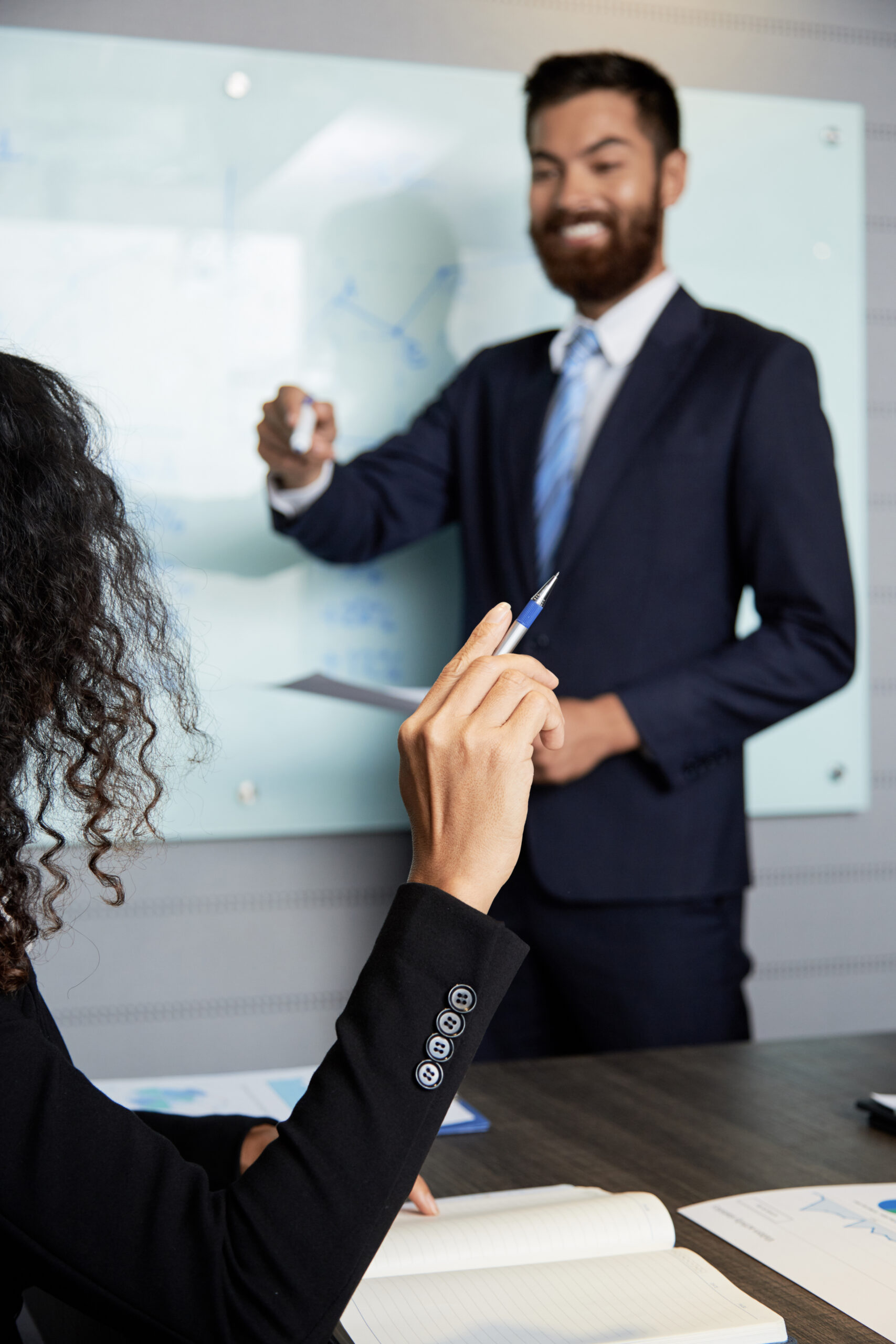 Crop businesswoman holding hand up while having business meeting with colleague in conference hall